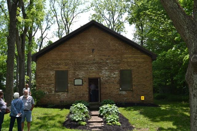 Exterior of the Pioneer Church, with a few people standing nearby