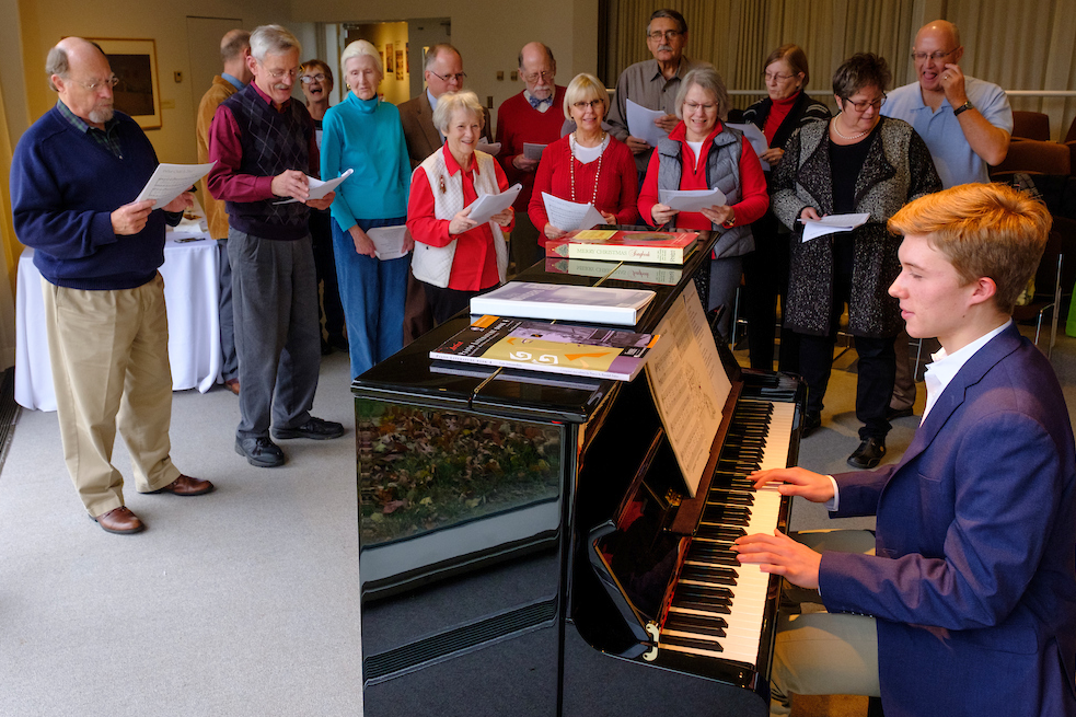 People sing carols near the piano as Jens Bartel plays