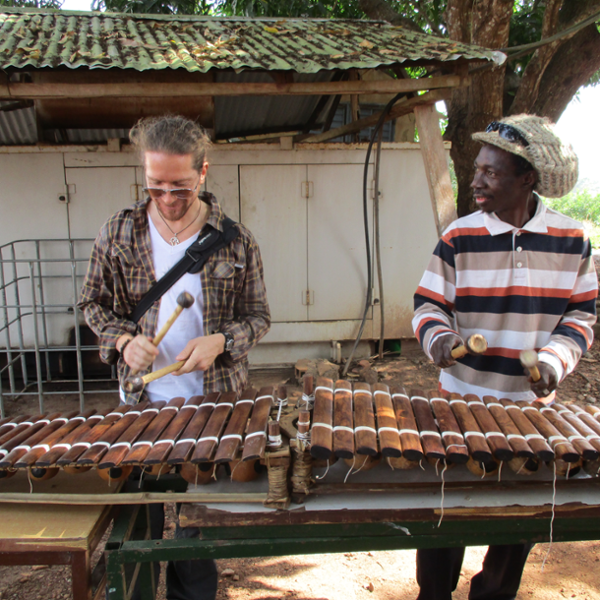 Jason Lee Bruns collaborates with another musician on mallets during a research trip to Africa 