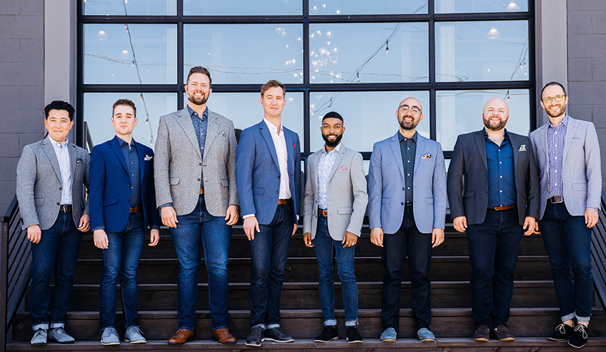 Members of Cantus posing as a group in jeans and button up shirts