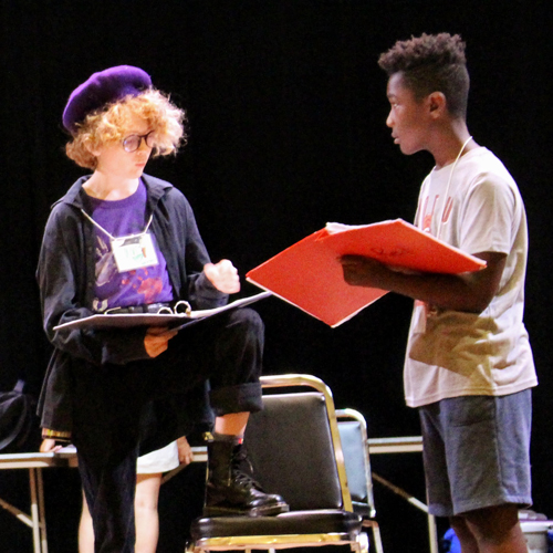 Two of the older participants learn their lines in preparation
