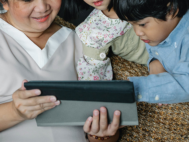asian woman and children using ipad