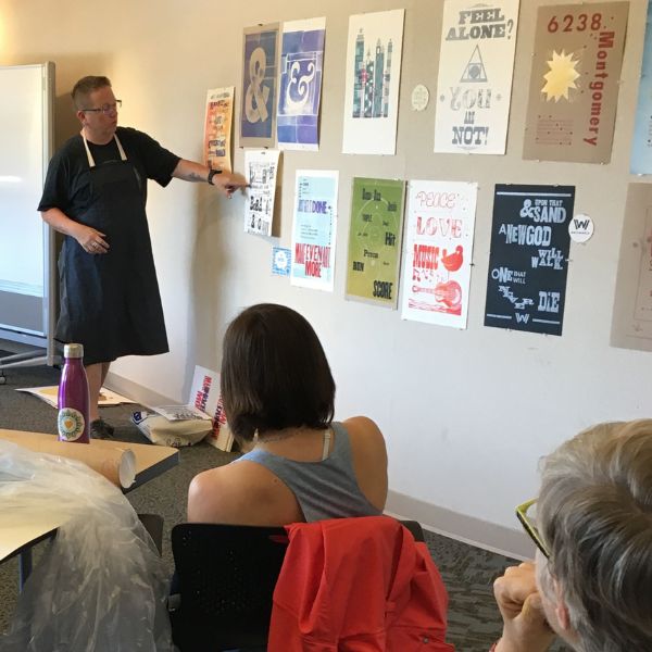 instructor presenting posters to class