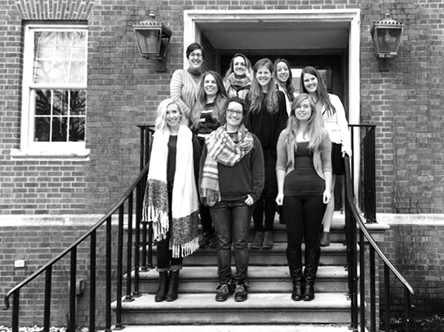Art history capstone student exhibitors pose on the steps of a building