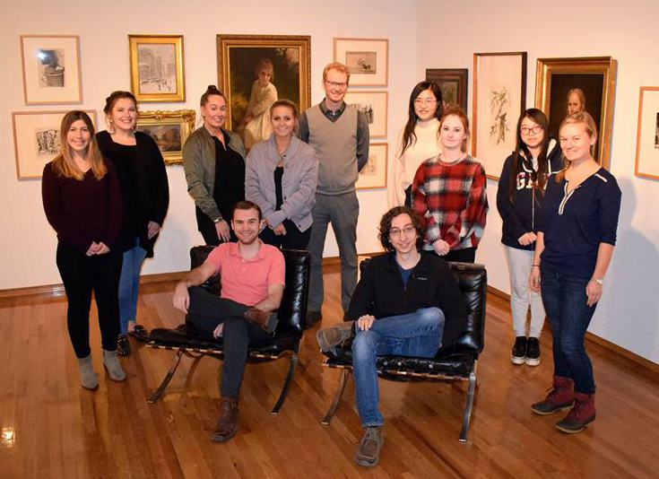 Capstone class poses for a group photo in Art Museum. See caption.