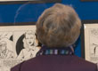 person viewing comic strip artwork