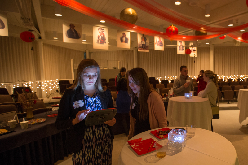 two female students talking to each other at a candlelit table at a party