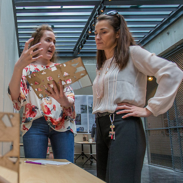 student presenting to faculty member