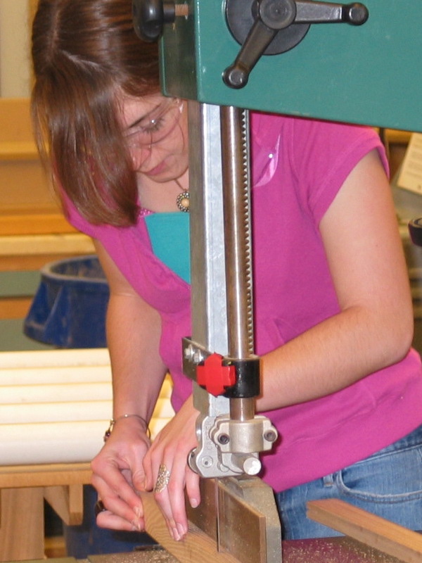 female student using machinery in woodshop
