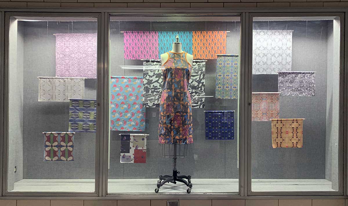 various rolls of textiles on display with a clothed mannequin