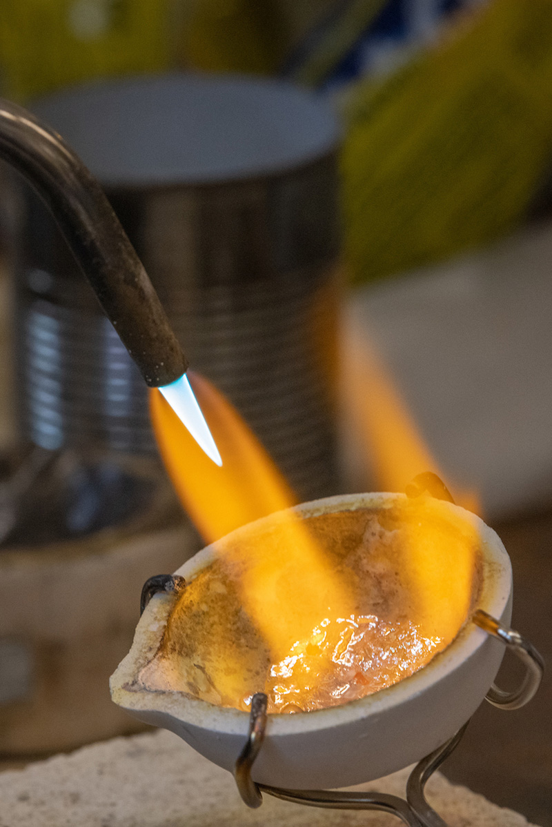 student melting metal to work with