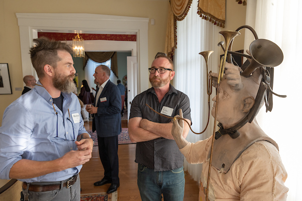 two men looking at an art piece