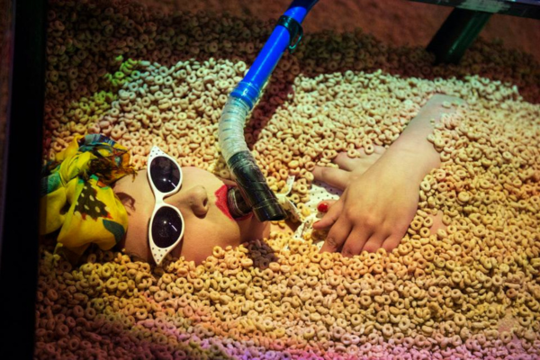 a woman wearing snorkling equipment in a bathtub of cereal