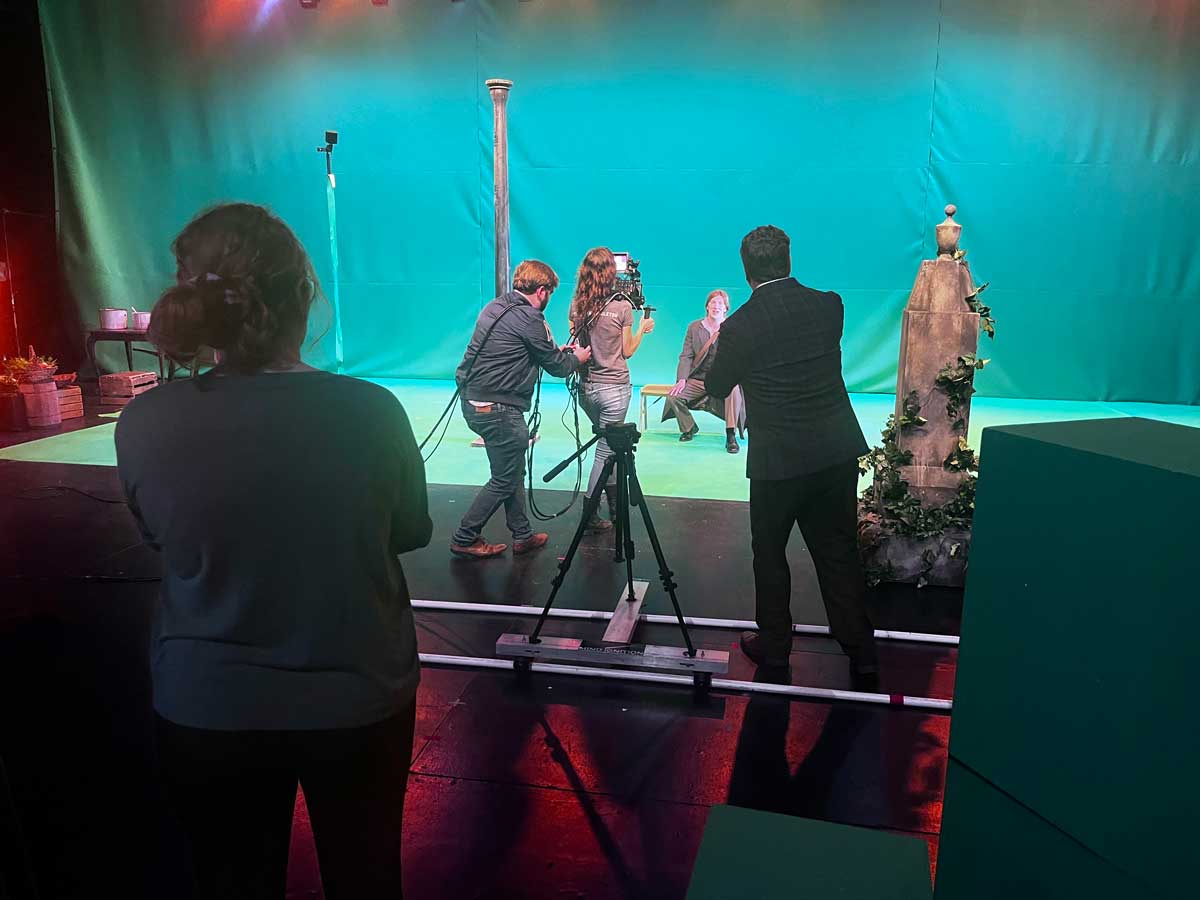 a behind the scenes view of a camera crew filming a scene with a green screen