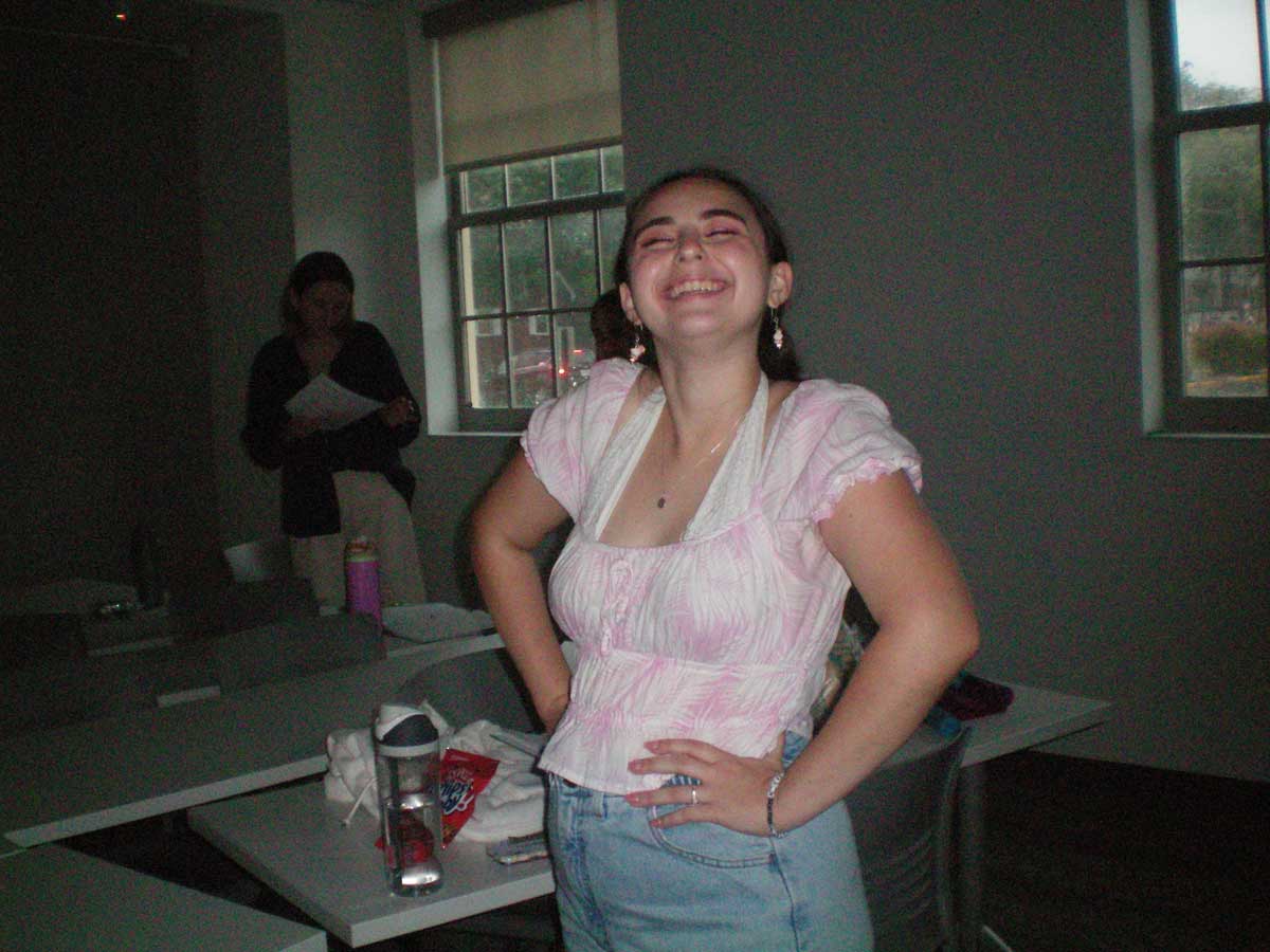 Mallory Branek posing for a picture while Lily Jackett studies the script
