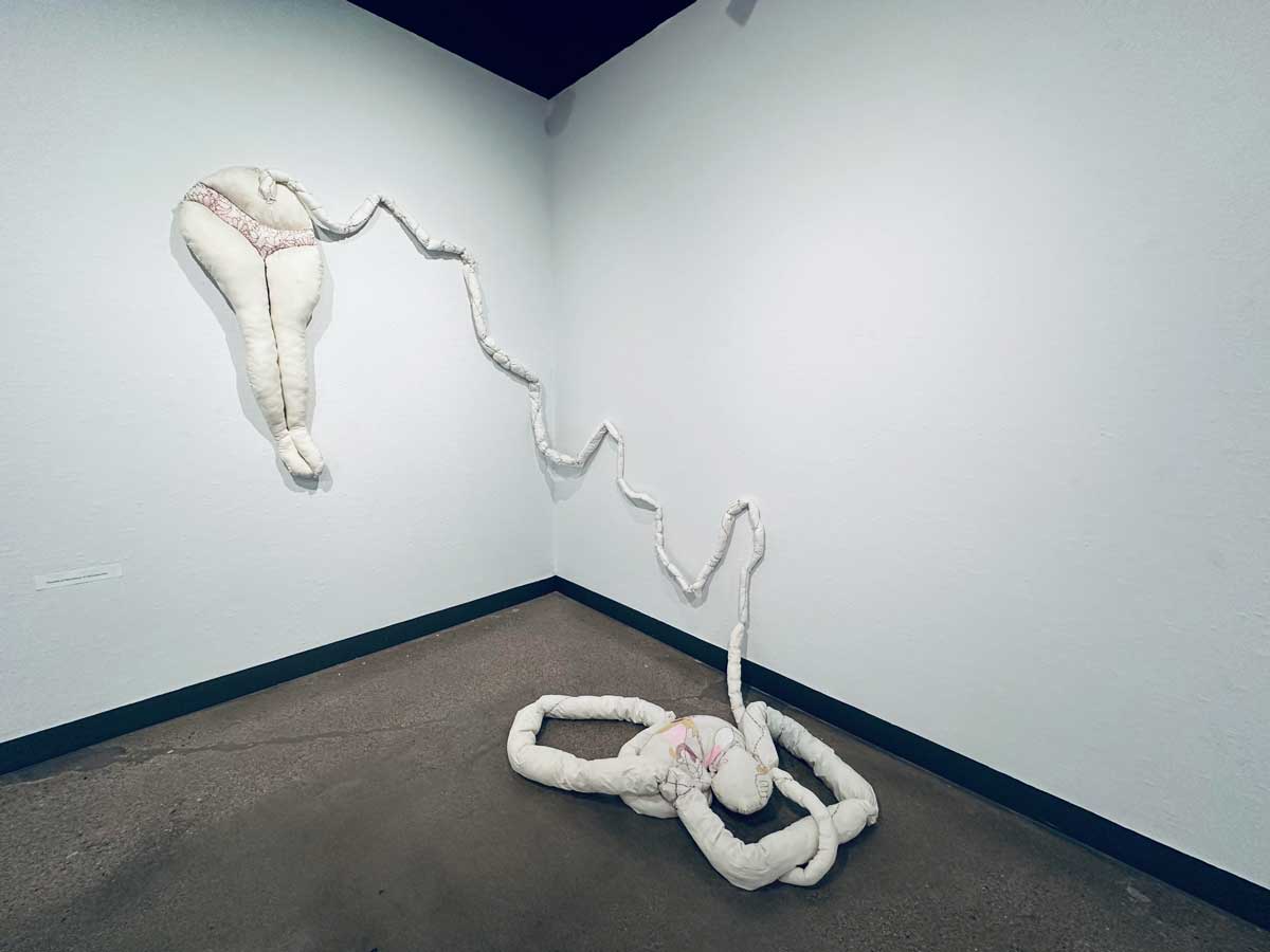 art piece depicting a woman giving birth and the baby is still attached by the umbilical cord