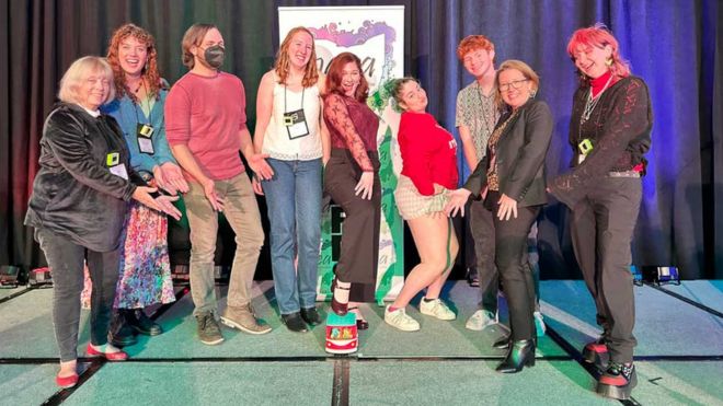 Miami University art education majors and faculty pose playfully onstage together at the 2025 OAEA Awards celebration.