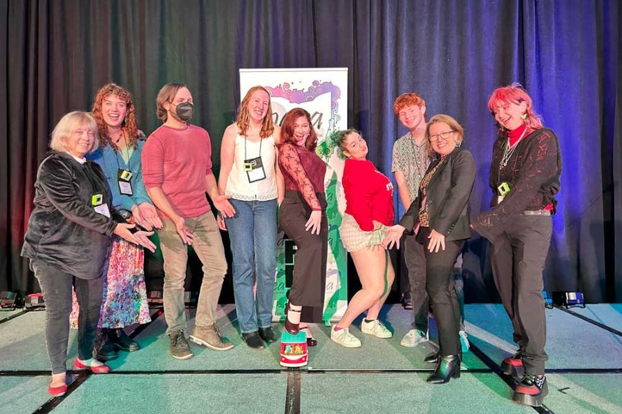 Miami University art education majors and faculty pose playfully onstage together at the 2025 OAEA Awards celebration.