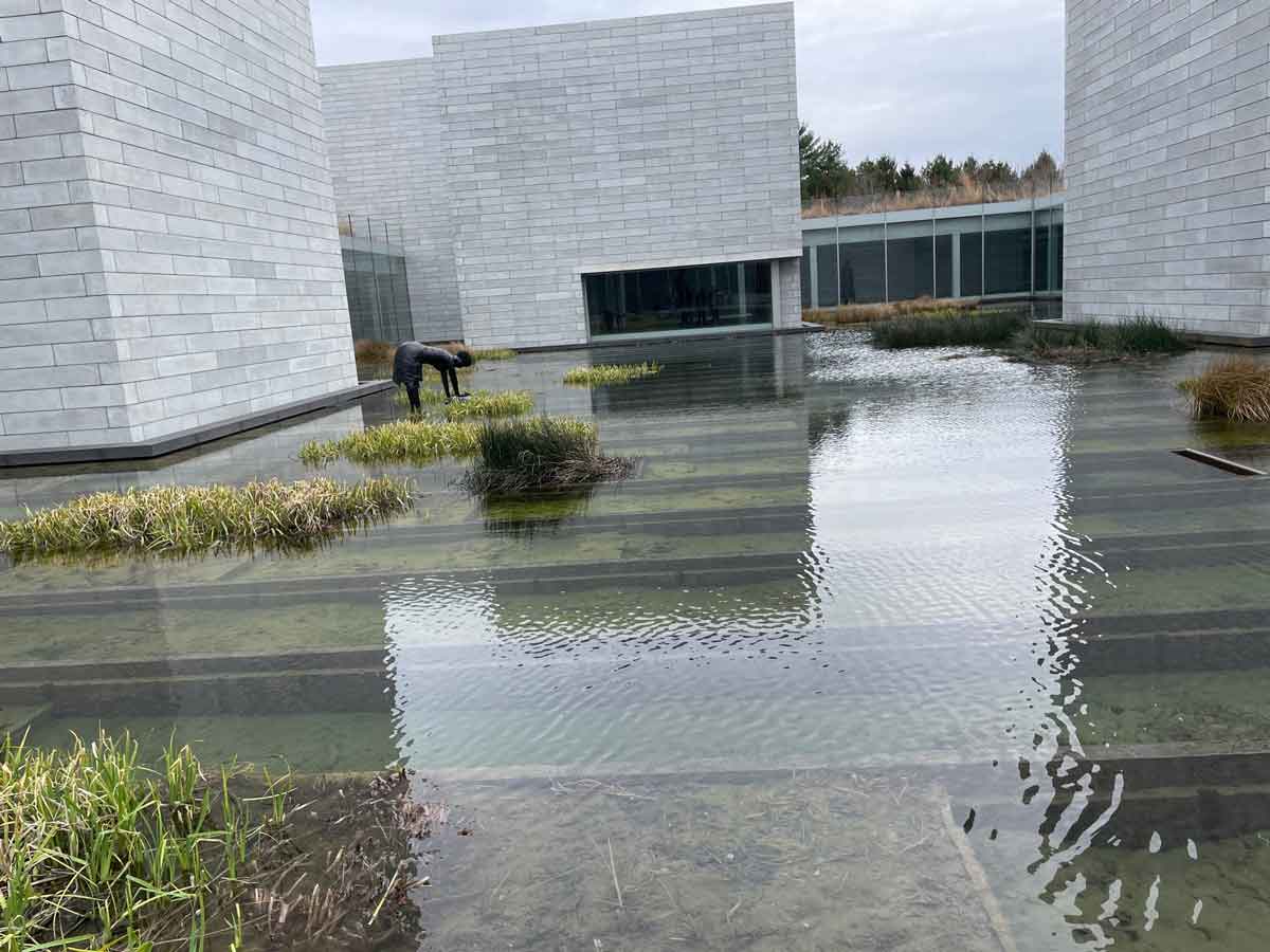 Reflecting water courtyard with landscaped islands at Glenstone Museum in Potomac, Maryland.