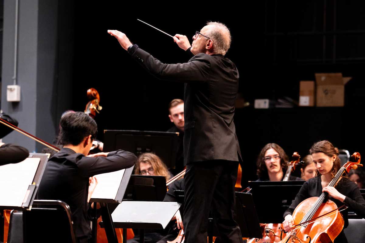 A man conducting the Miami University Symphony Orchestra.