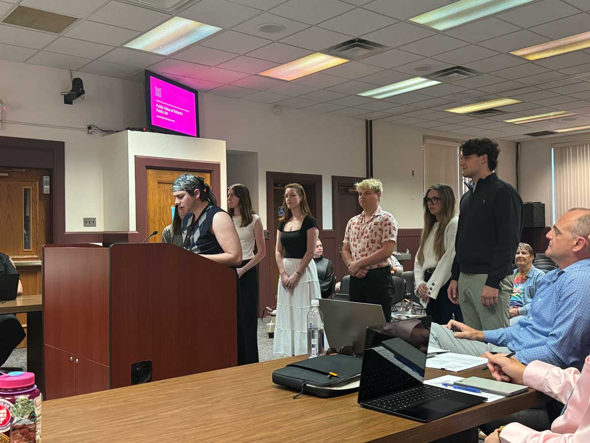 Students from Miami University’s Policy and Advocacy in the Arts course present original research at a podium.