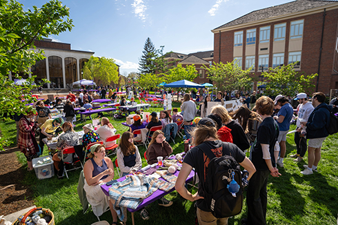 A crowd of people filling the Arts Quad at Miami University interacting with various table of art activities