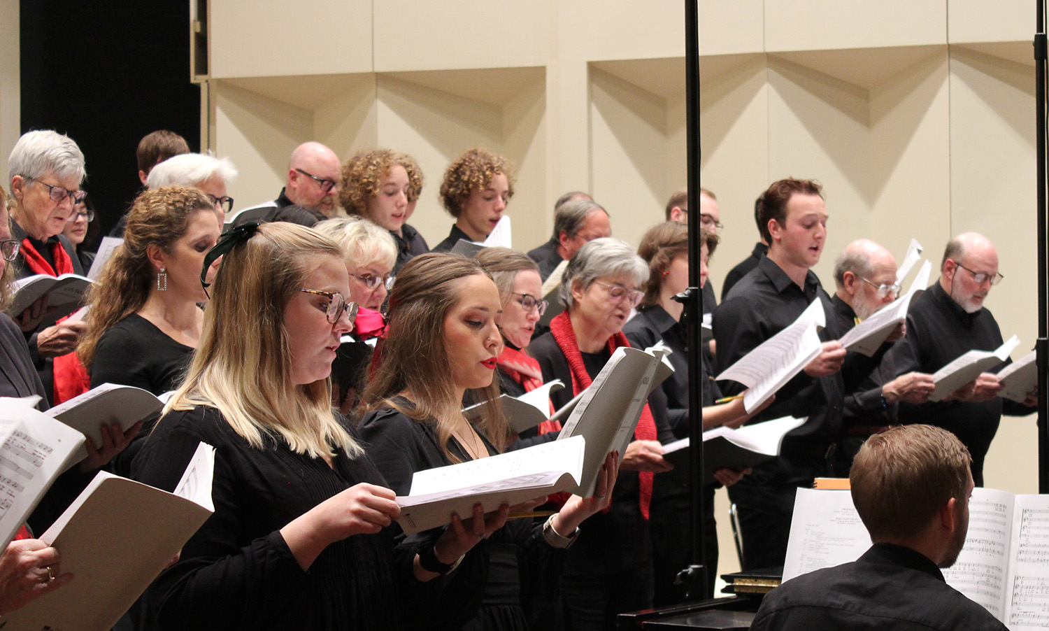 A group of men and women of various ages singing together