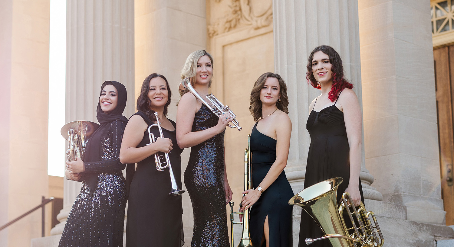 the 5 women members of Seraph Brass pose on the steps of a greek revival building holding their instruments 2 trumpets a french horn, trombone and tuba