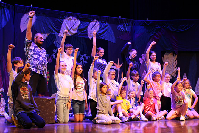 Campers in colorful outfits perform in the final show
