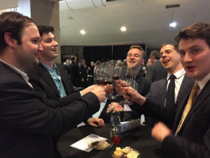 young alumni toast with wine glasses