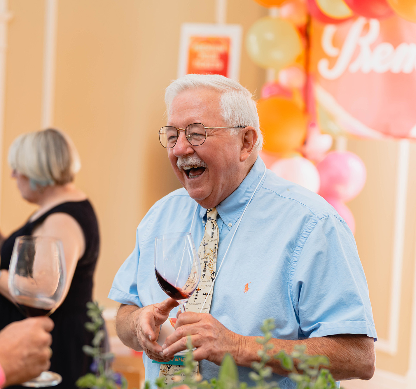 Jack Keegan laughing while holding a glass of wine