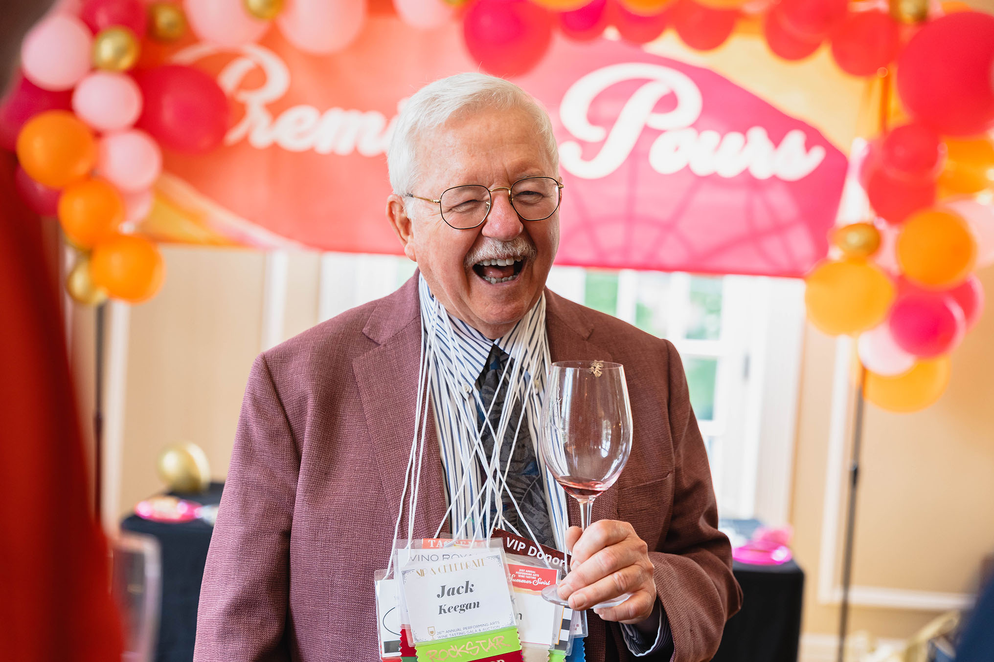Jack Keegan laughing while holding a glass of wine