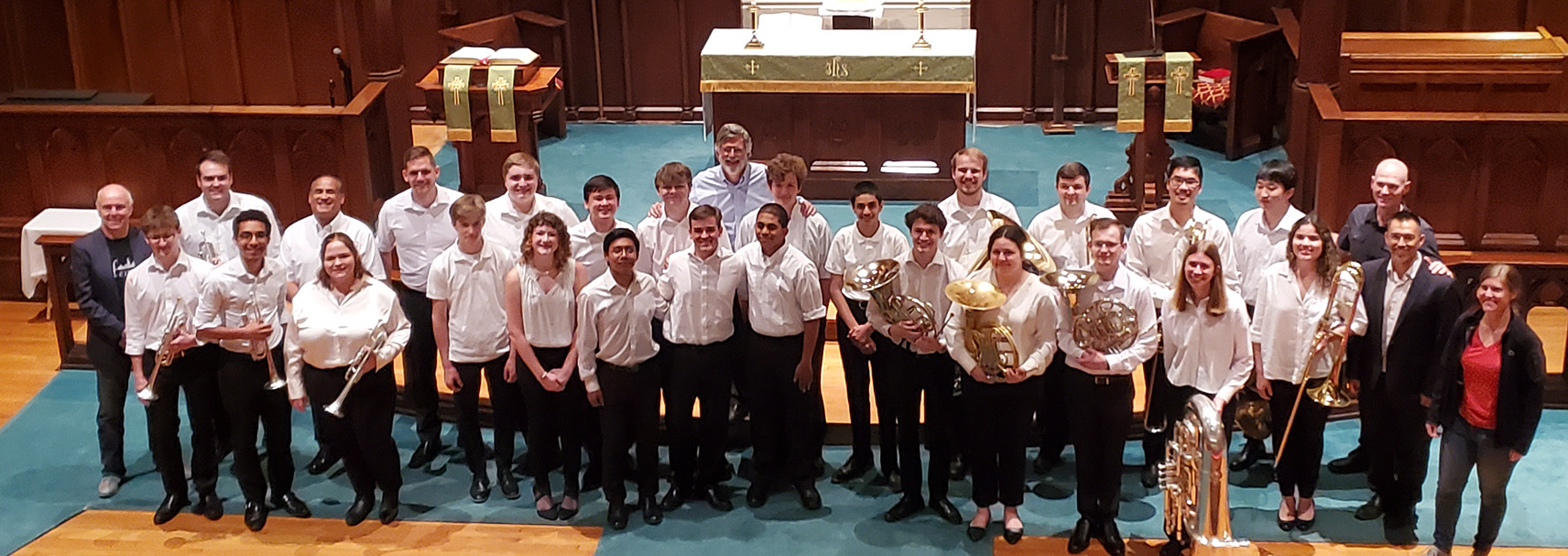Members of 2024 CSO Brass Institute pose in the front of a sanctuary with their instruments