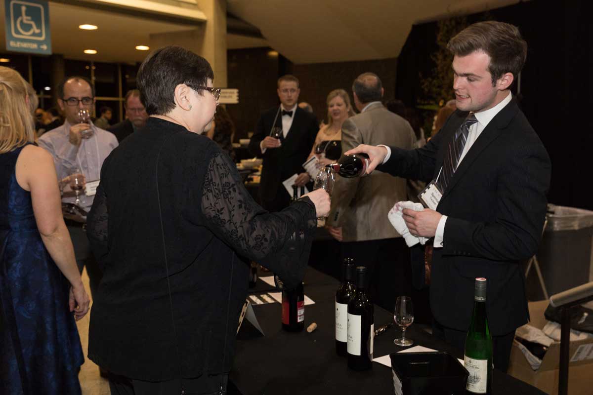 wine vendor pouring wine into an attendee's wine glass