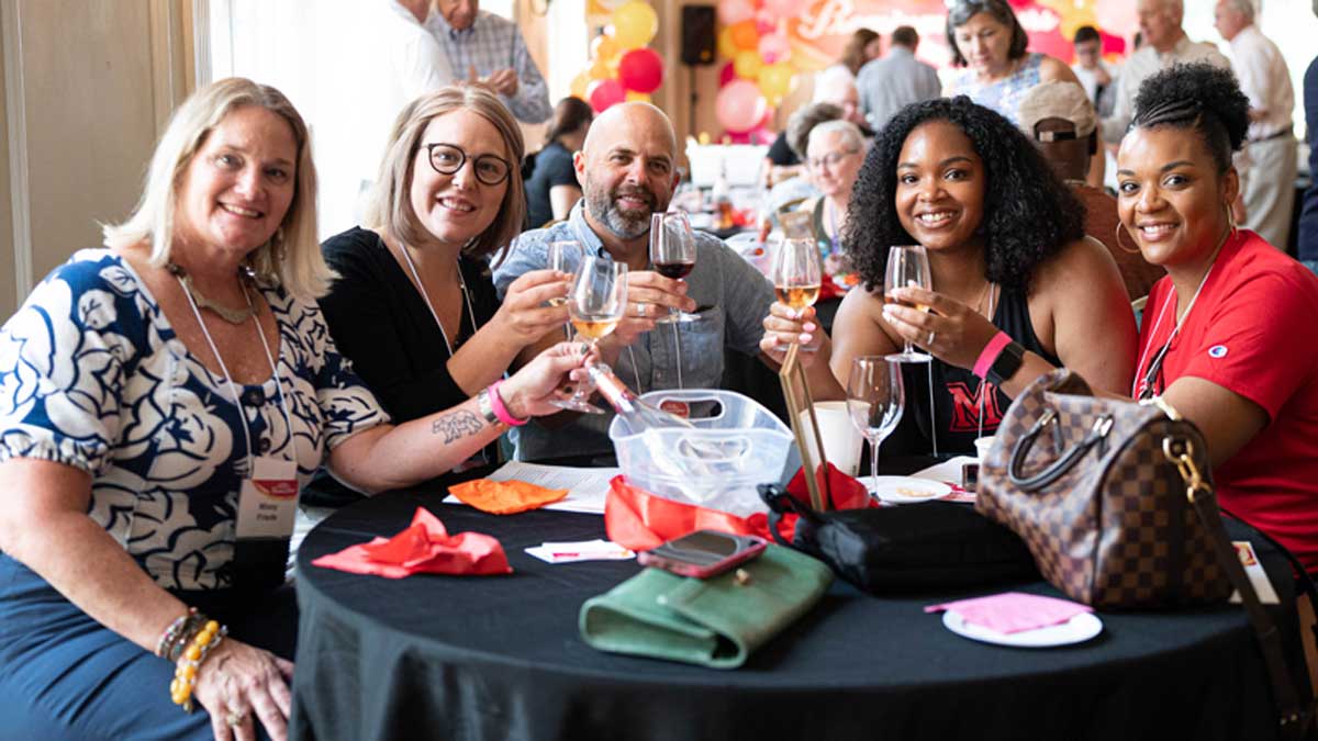 Missy Friede, alumni, and guests raise their glass