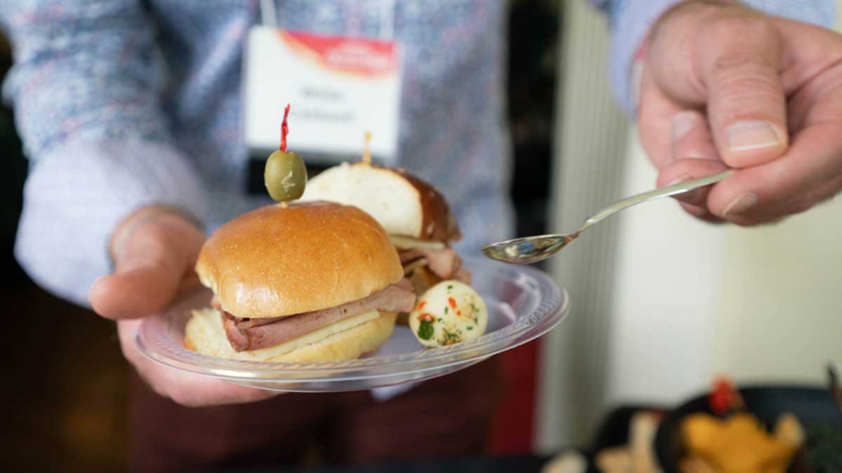  A close up of a plate filled with delicious looking small sandwiches and charcuterie 