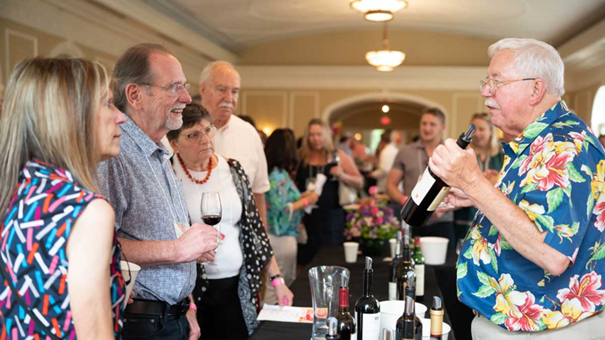  Jack Keegan holds court at the Premium Pours table with several attendees