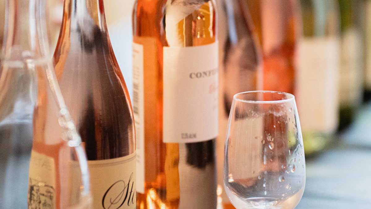  An artistic shot of a row of bottles of rose wine 
