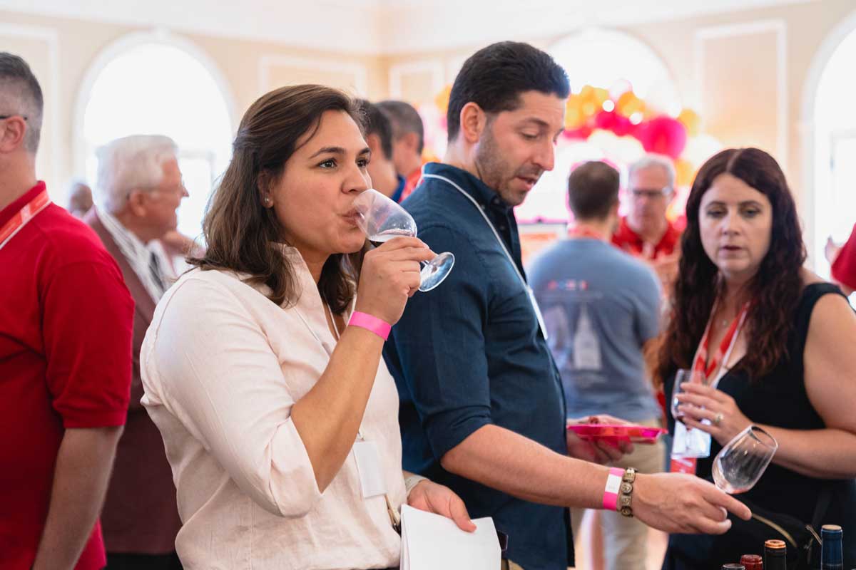 Miami University alumni sampling wine and socializing at a wine tasting event in the Oxford Community Arts Center.