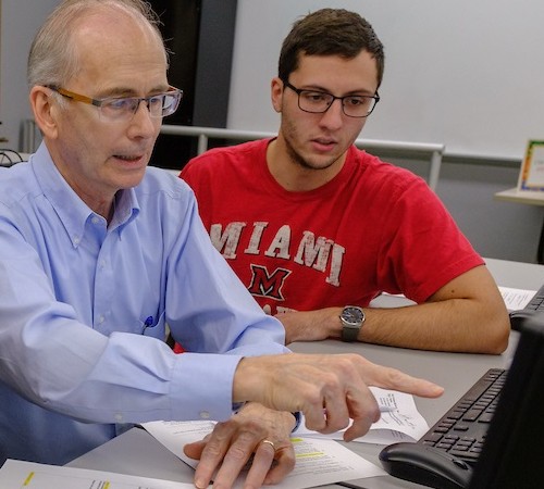 Dr. Kiper and a student working at a computer