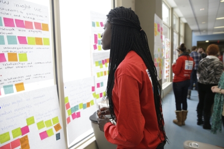 Female student looking at post-it notes on the wall