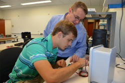 An ECE professor helping a student with a lab