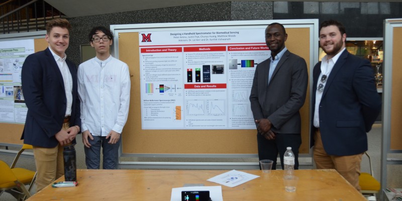 Four CPB students in front of their senior design poster