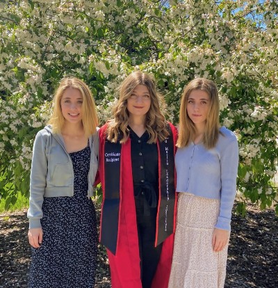 Jacobs Sisters, Elsa, Laura, and Allison Jacob standing outside in front of trees