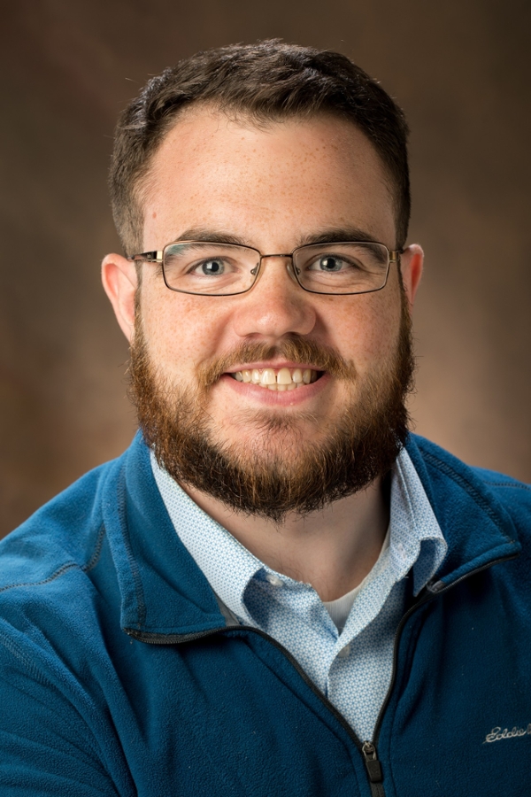 Nick Stanford headshot wearing blue shirt and smiling