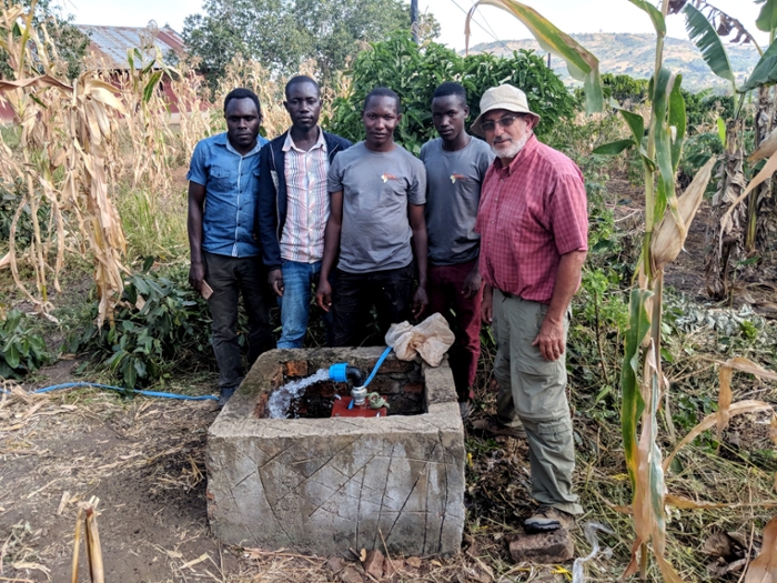 Chuck Dragga in Uganda with a work crew behind one of their projects