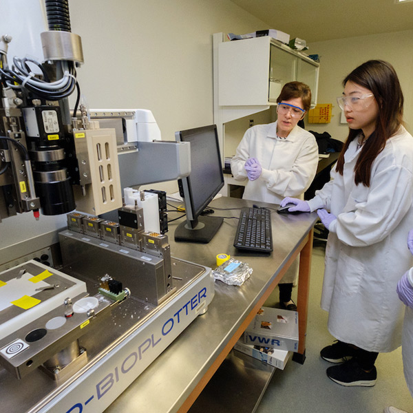 student working with a faculty member in a lab