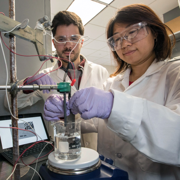 student with faculty member in a chem lab