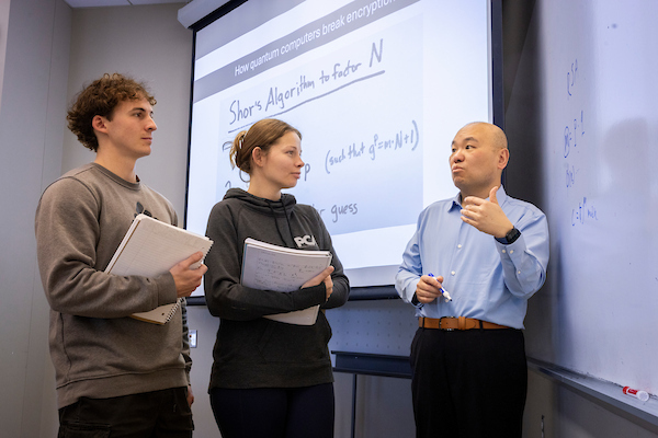 professor at a white board teaching students