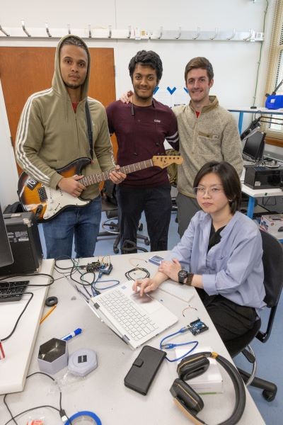 Three students working with Dr. Lei Kerr